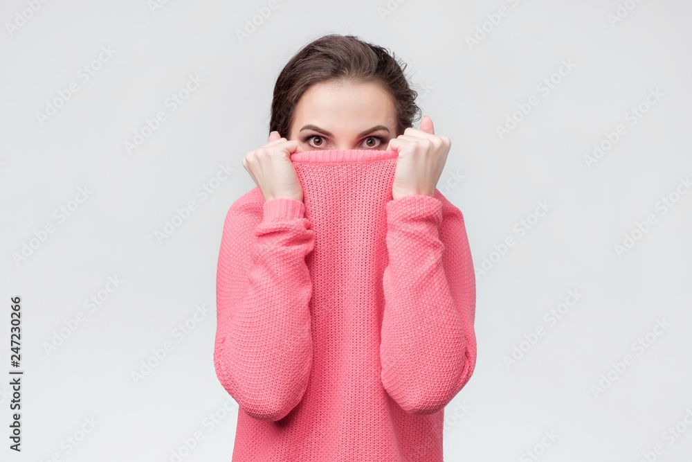 Girl pulling her trendy sweater over head hdidng from problems. Girl pulling her trendy sweater over head hdidng from problems.