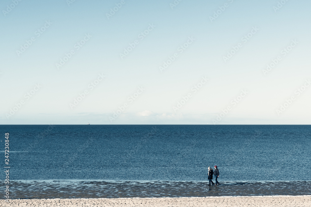 two person at the beach in a minimalist wintry composition 