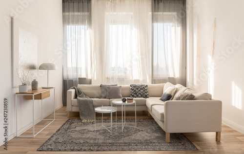 Beige grey and white living room interior design with corner sofa and two coffee tables