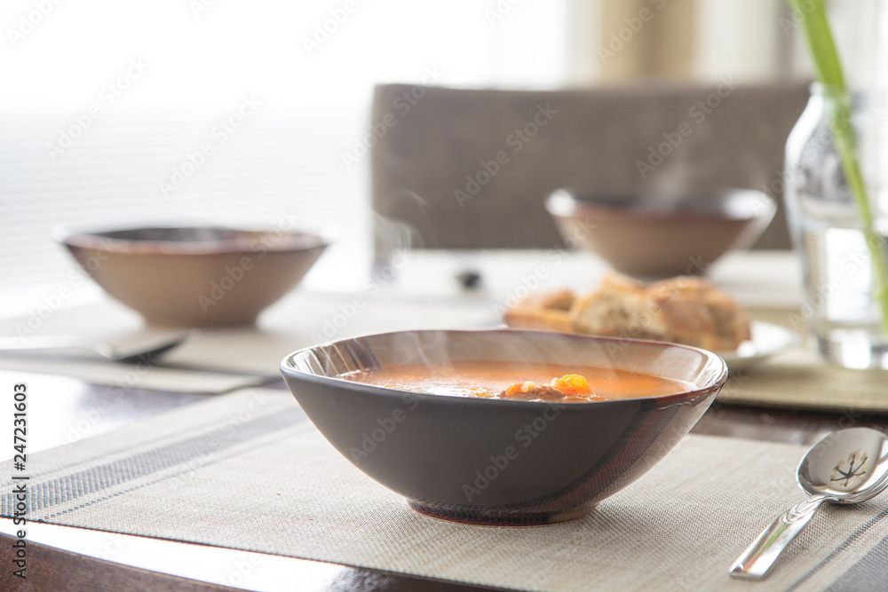 Lunch table with steaming hot stew bowl, homemade food Lunch table with steaming hot stew bowl, homemade food