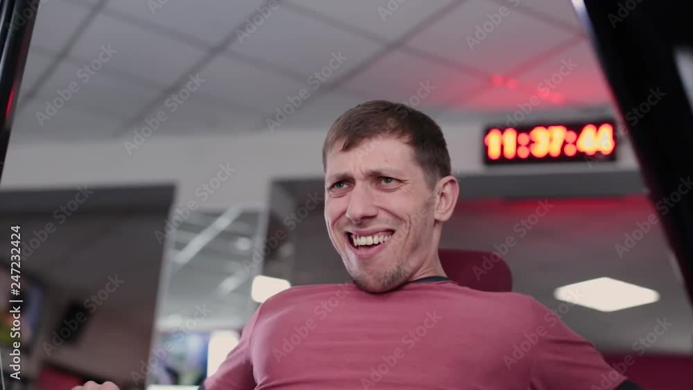 Athletic and attractive man trains pectoral muscles on a simulator in the gym. Athletic and attractive man trains pectoral muscles on a simulator in the gym.