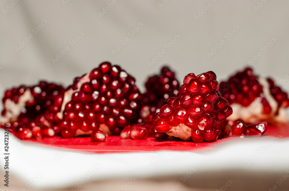 Opened and cutted pomegranate on the red board Opened and cutted pomegranate on the red board