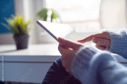 Young girl in blue sweater hold tablet and shopping online. Close up technology using.