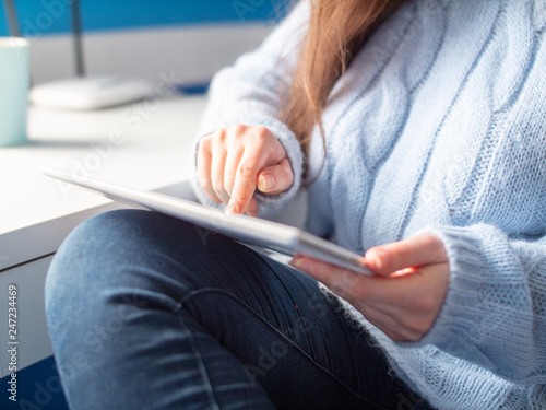 Young girl in blue sweater hold tablet and shopping online. Close up technology using.