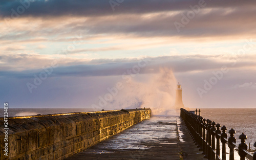 Stormy sea crashing over Tynemouth Pier, Tyneside, Engalnd, UK . In early morning light and sunrise. © coxy58