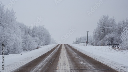 Snowy country road leading into the horizon