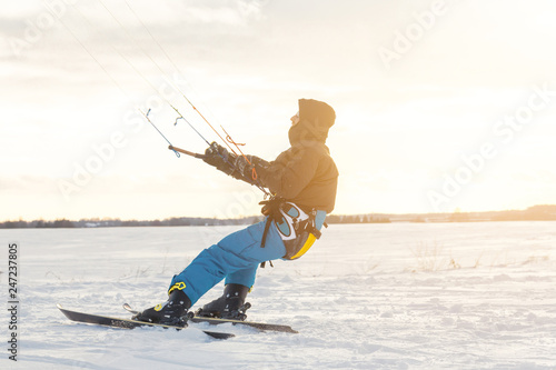 The skier goes on the snow field with kyte photo