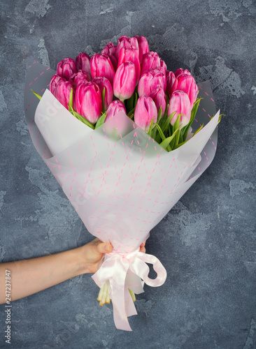 Woman hand holding bouquet of tulips flowers