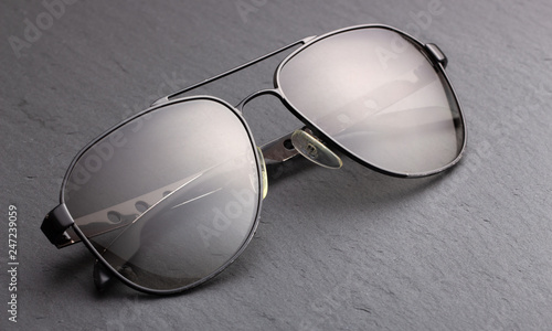 Black polarizing sunglasses in a metal frame on a black fabric background