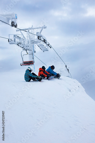 Snowboarder sitting and looking at mountain chain in the background