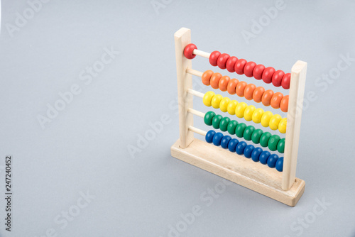 Traditional counts abacus with colorful wooden beads on gray background. Toy abacus to learn counting. Colorful children counting frame for kids. Counts show  one. Copy space. Top view.