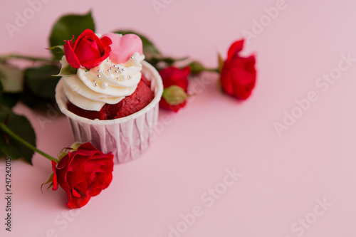 cupcake roses and hearts on a pink background.copy spase.Chocolate cupcakes decorated with cream rose