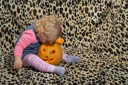 Tableau sur toile a little blonde girl is interested in two cut for halloween pumpkins