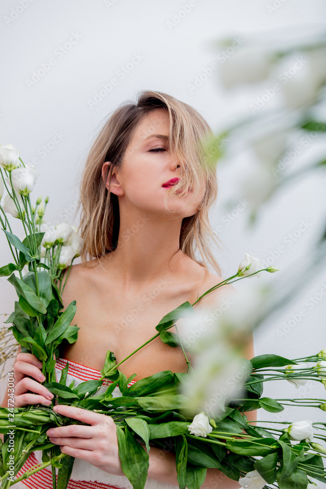 Beautiful woman with white roses bouquet dressing in a white dress. Springtime concept or Valentines Day holiday