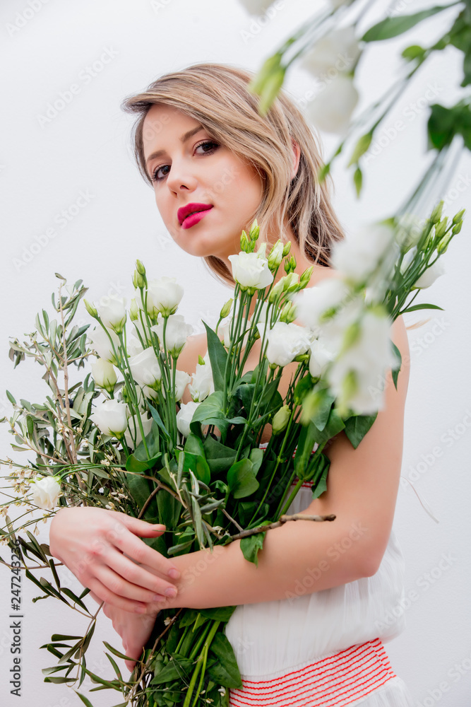 Beautiful woman with white roses bouquet dressing in a white dress. Springtime concept or Valentines Day holiday Beautiful woman with white roses bouquet dressing in a white dress. Springtime concept or Valentines Day holiday