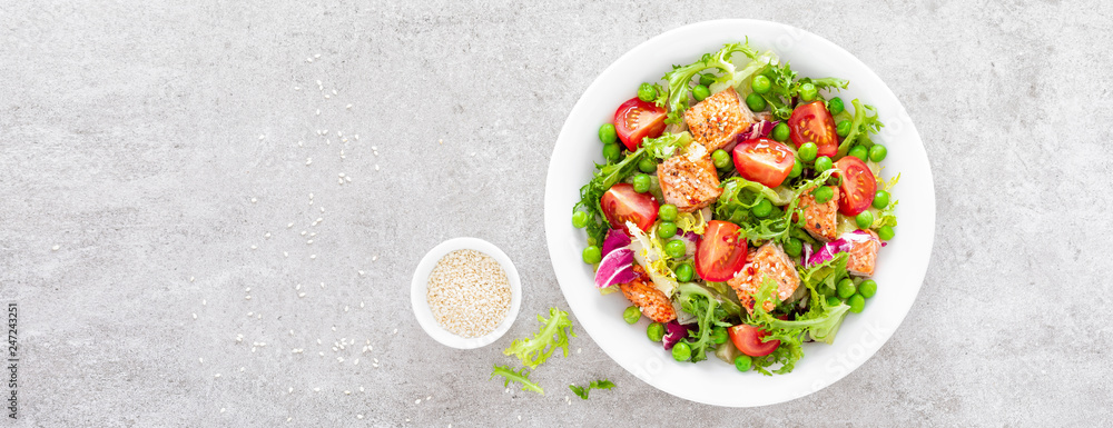 Healthy lunch vegetable salad with baked salmon fish, fresh green peas, lettuce and tomato. Top view Healthy lunch vegetable salad with baked salmon fish, fresh green peas, lettuce and tomato. Top view