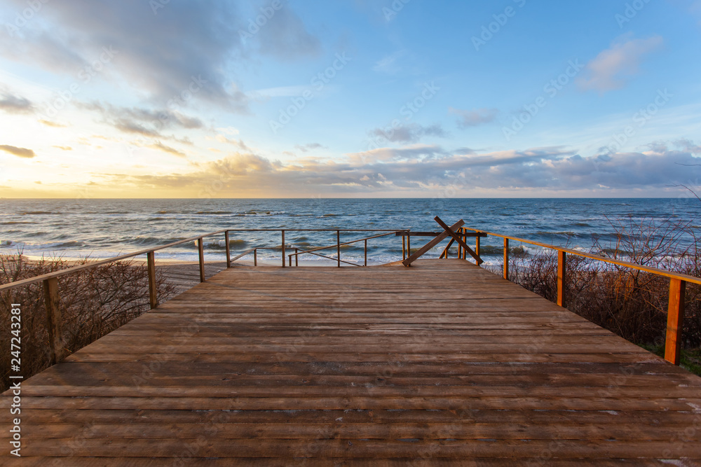 Obraz premium view of the colorful sunset over the sea from a wide wooden veranda