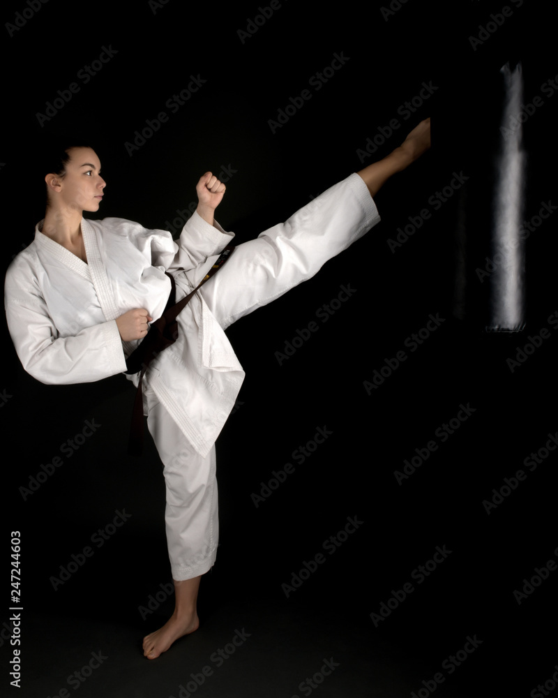 Young woman dressed in traditional kimono practicing her karate moves