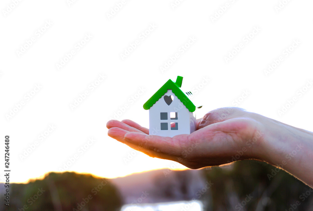 Close up of hands holding house or home model Close up of hands holding house or home model
