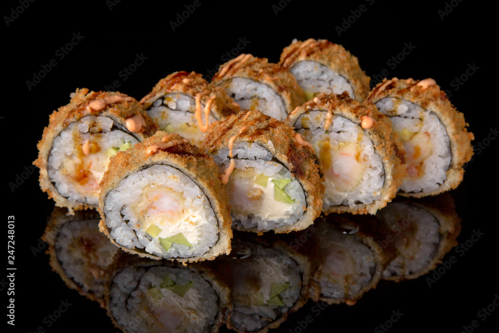 Hot fried Sushi Roll with shrimp, scallop, avocado and cheese on black background. Sushi menu. Japanese food. Hot fried Sushi Roll with shrimp, scallop, avocado and cheese on black background. Sushi menu. Japanese food.