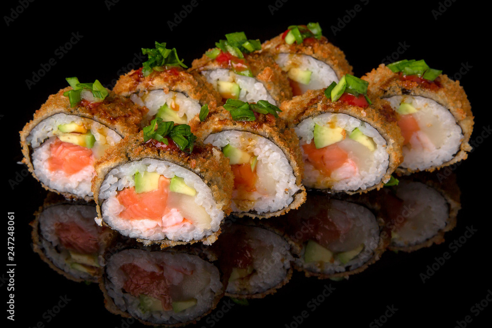 Hot fried Sushi Roll with smoked salmon, scallops, shrimp, avocado and cheese on black background. Sushi menu. Japanese food. Hot fried Sushi Roll with smoked salmon, scallops, shrimp, avocado and cheese on black background. Sushi menu. Japanese food.