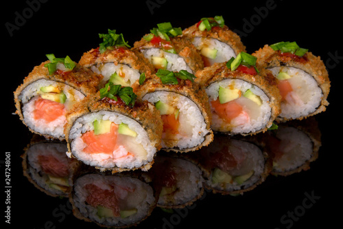 Hot fried Sushi Roll with smoked salmon, scallops, shrimp, avocado and cheese on black background. Sushi menu. Japanese food. 