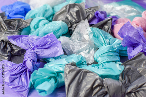 Multi-colored plastic garbage bags rolled into bows