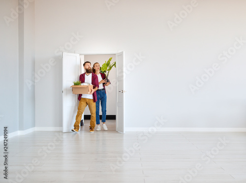 Obraz na płótnie happy young married couple moves to new apartment