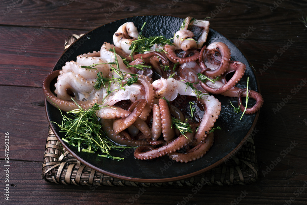 Ταπετσαρία Octopus cooked with parsley and oil in a porcelain dish on rustic wood