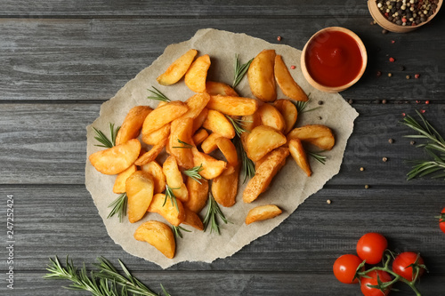 Flat lay composition with baked potatoes and rosemary on wooden background