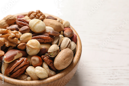 Bowl with organic mixed nuts on table, closeup. Space for text