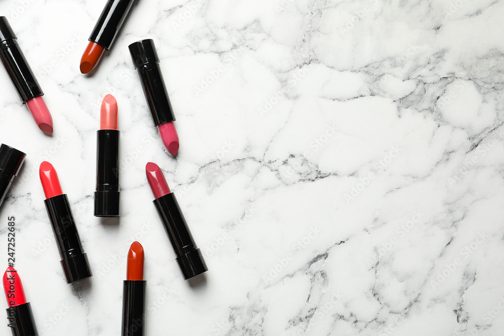 Different lipsticks and space for text on marble background, flat lay Different lipsticks and space for text on marble background, flat lay