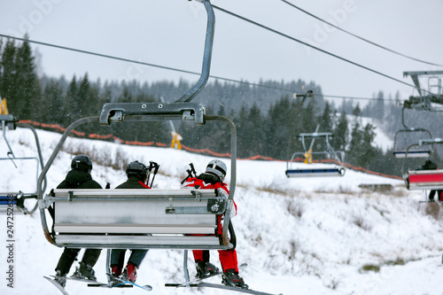 Chairlift with people at ski resort. Winter vacation