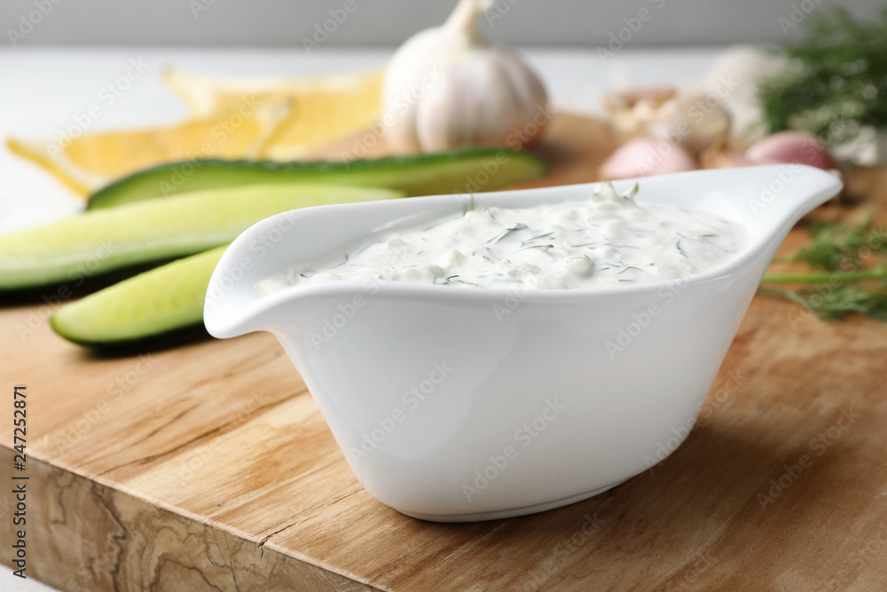 Cucumber sauce with ingredients on wooden board. Traditional Tzatziki Cucumber sauce with ingredients on wooden board. Traditional Tzatziki
