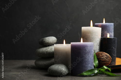 Spa composition with burning candles on table, space for text