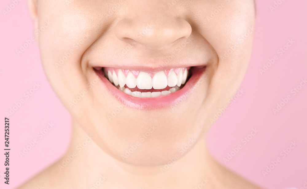 Obraz premium Młoda kobieta z pięknym uśmiechem na kolorowym tle, zbliżenie