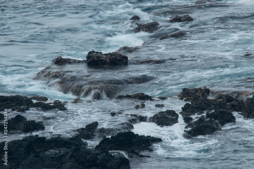 Naklejka premium waves crashing on rocks