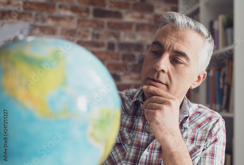 Man holding a globe and finding locations photo
