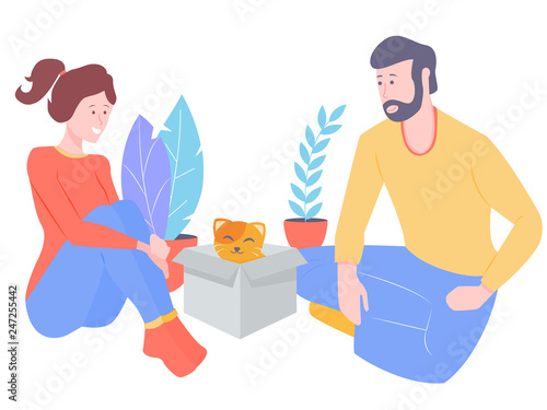 Young couple welcomes a new member of the family. A fluffy cat looks out of the box.