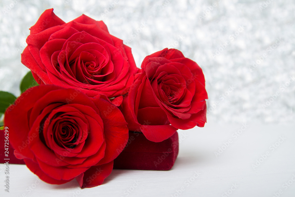 Three Red Roses and jewelery present box with boke Background. copy space - Valentines and 8 March Mother Women's Day concept. Three Red Roses and jewelery present box with boke Background. copy space - Valentines and 8 March Mother Women's Day concept.