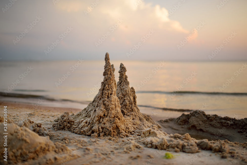 Sand castle built on the beach of Baltic sea on beautiful summer evening.