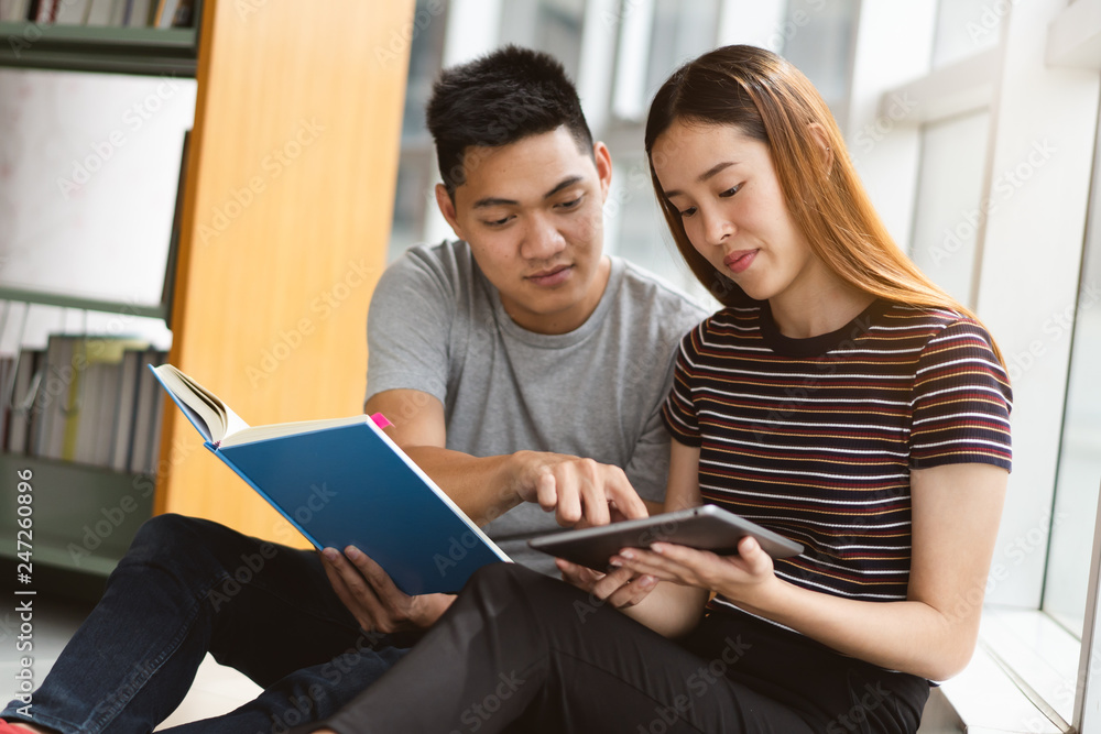 Group of asian students researching data for homework assignment in library. Group of asian students researching data for homework assignment in library.