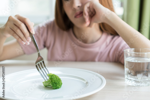 Woman on dieting. Depressed teen looking at her empty plate dinner. photo