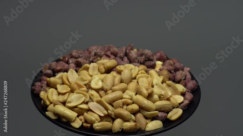 Peanuts. Mixed Peanuts in rotation. Snack closeup.  Peanuts in a bowl. Selective focus. grey background. Studio shot. Healthy food concept.
