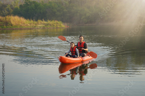 Father and daughter rowing boat on calm waters