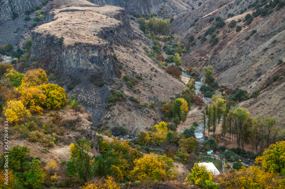 Garni gorge with basalt columns and rocky peninsula framed by the mountain river Azat clogged with huge stone boulders

