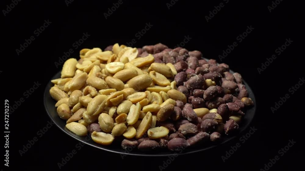 Peanuts. Mixed Peanuts in rotation. Snack closeup. Peanuts in a bowl. Selective focus. black background. Studio shot. Healthy food concept. Peanuts. Mixed Peanuts in rotation. Snack closeup. Peanuts in a bowl. Selective focus. black background. Studio shot. Healthy food concept.