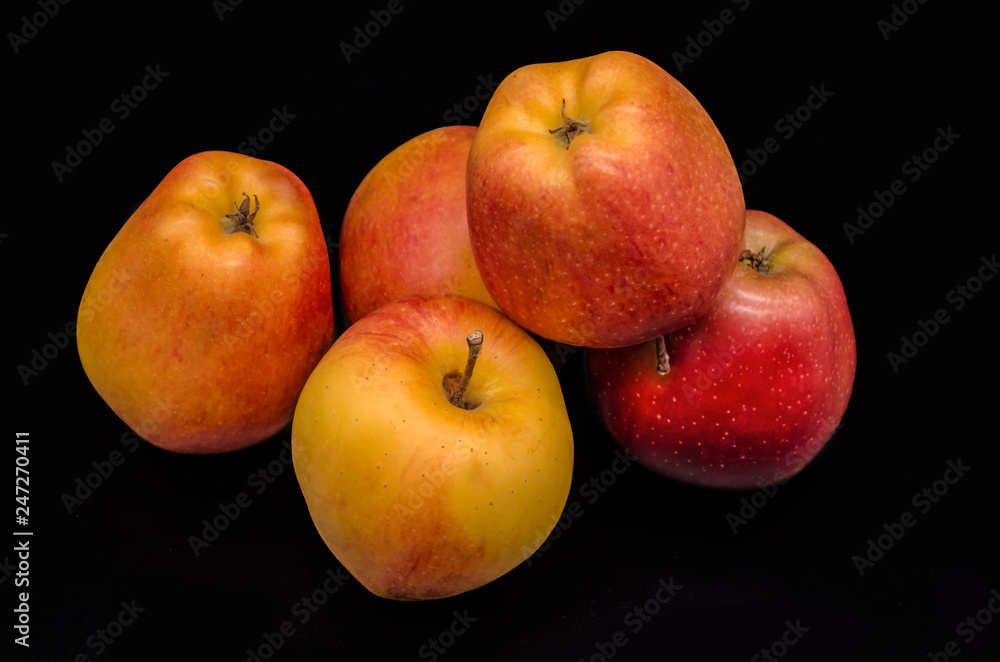 A group of five beautiful yellow with red spots of ripe apples on a black background
A group of five beautiful yellow with red spots of ripe apples on a black background