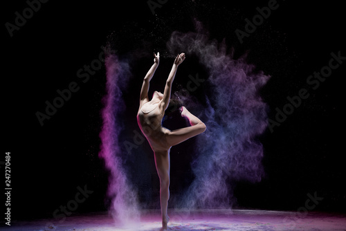 Fototapeta Majestatyczna dancingowa kobieta w kolorowym latającym proszku