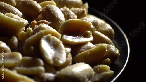 Peanuts. Mixed Peanuts in rotation. Snack closeup.  Peanuts in a bowl. Selective focus. black background. Studio shot. Healthy food concept.